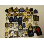 A selection of Royal Navy badges including officer's embroidered cap badges,