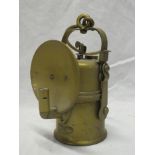 An old brass miners open flame lamp by the Wolf Safety Lamp Co,