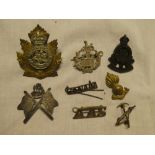 A small selection of military badges including silver/silver-plate Essex Regt Officers badge,