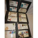 Three folder albums containing a collection of over 170 GB first day covers 1964-1984