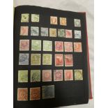 A folder album containing a selection of mixed World stamps including some early examples