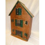 An old wooden doll's house-style model building in the form of a three storey mill with opening