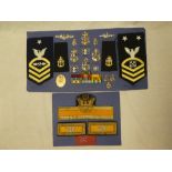 A display of US Navy Chief Petty Officer's badges and insignia including submarine and diver badges