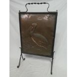 An old iron rectangular fire screen with inset copper rectangular panel depicting a pelican