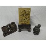 An Eastern carved soapstone rectangular panel decorated with flowers on scroll-shaped stand,