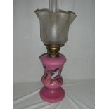 A Victorian pink opaque glass floral decorated oil lamp with detachable reservoir and etched glass