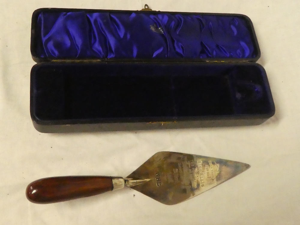 A silver plated presentation trowel "This trowel was used by Miss Ellis to lay the first brick of
