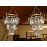 A pair of brass three tier ceiling electroliers with glass lozenge droplet decoration