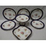 An Aynsley china part dessert set comprising circular comport with floral decoration within blue