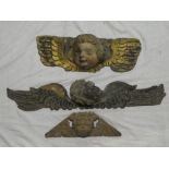 An old carved and painted wood plaque in the form of an angels face with wings,