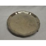 A late Victorian silver circular waiter tray with engraved crest and decorated edge,