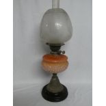 A Victorian brass oil lamp with pink-tinted glass scroll reservoir and etched glass shade (shade in