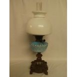 A late Victorian oil lamp with ornate cast iron base,