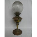An Edwardian brass oil lamp with pedestal column and etched brass shade