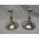 A pair of sterling silver squat-shaped candlesticks with circular spreading bases,