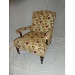 A pair of Victorian mahogany open arm easy chairs upholstered in floral fabric on turned legs with