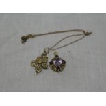 A 15ct gold floral pendant set seed pearls together with chain and a 9ct gold pendant set amethyst