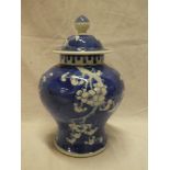 A 19th Century Chinese pottery baluster-shaped vase and cover with blue and white blossom