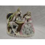A Continental china figure of a male and female playing chess with other female in attendance,