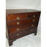 An old mahogany chest of two short and three long drawers with brass ring handles on bracket feet