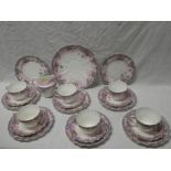 An Edwardian china tea set with floral and pink decoration comprising six teacups, six saucers,
