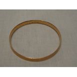 A 9ct gold circular bangle with engraved decoration
