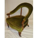 A Victorian walnut open arm easy chair upholstered in green fabric on turned legs with casters