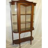 A late Victorian inlaid mahogany curved display cabinet with fabric lined shelves enclosed by a