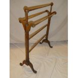 An Edwardian mahogany towel rail with scroll fluted supports