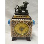 A Continental Chinese-style mantel clock with gilt circular dial in ceramic square case with temple