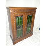 A good quality 1920's Arts & Crafts-style carved oak bookcase with shelves enclosed by two leaded