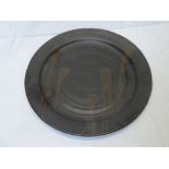 A Studio pottery circular platter with brown glazed decoration, signed "MW",