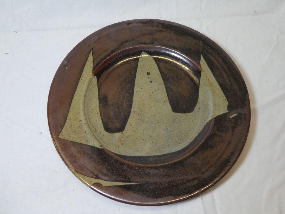 A Winchcombe Studio pottery circular plate with grey and brown decoration by Ray Finch,