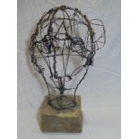 A wirework head figure by Julian Dyson on rustic wooden base,