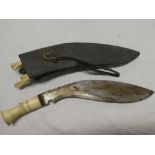 An old Gurkha kukri with 11" curved blade and bone mounted hilt in leather sheath