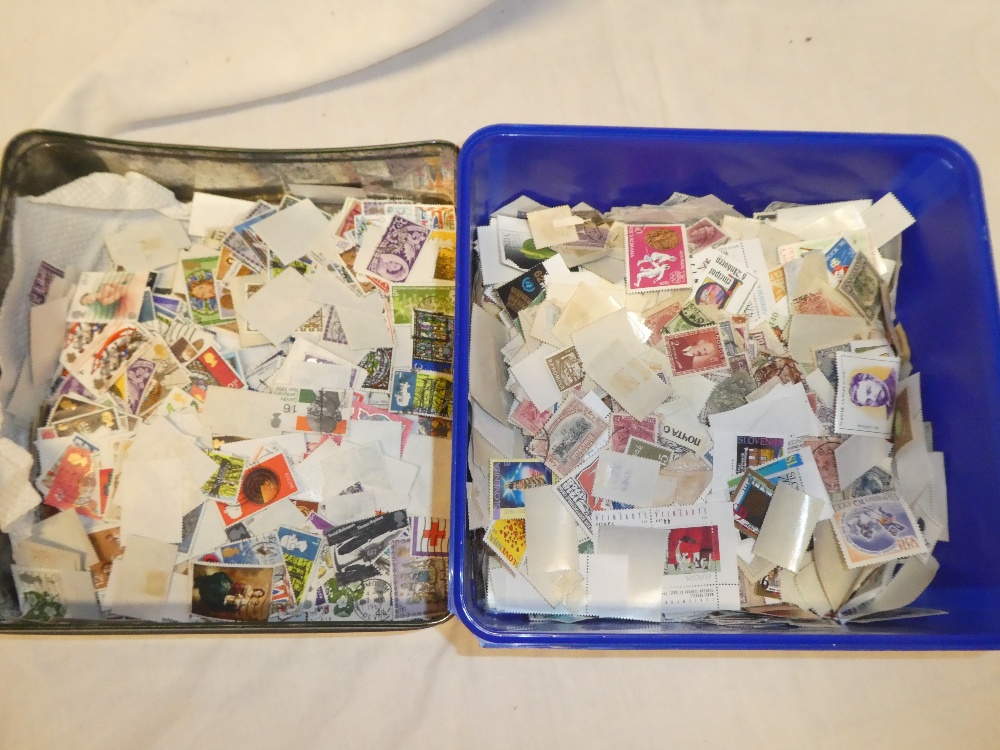 A tin of World stamps off paper and a tin of GB commemorative stamps off paper (2)