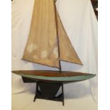 An old wooden model pond yacht with linen sails and stand,