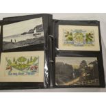 An album of various postcards including eight embroidered silk postcards, Louis Wain cat postcard,