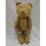 An old plush covered straw-filled teddy bear 20" long