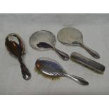 A George V silver mounted three piece dressing set comprising hand mirror,