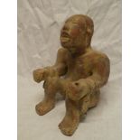 An unusual South American terracotta figure of a seated male,