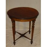 An Edwardian mahogany circular occasional table on turned fluted legs joined by a cross over