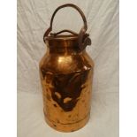 An old copper cylindrical milk churn with swing handle,