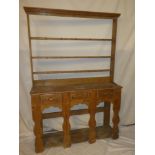 A small 19th Century polished pine farmhouse dresser with three drawers in the frieze and open pot