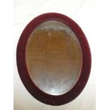 A 19th Century oval wall mirror in red velvet decorated frame,