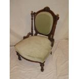 A Victorian carved walnut occasional chair with upholstered seat and back on turned tapered legs