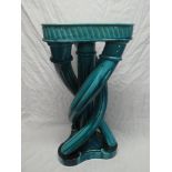 A turquoise glazed pottery triangular jardiniere stand with entwined stem and triangular base,