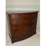 A Victorian figured mahogany bow-front chest of two short and three long drawers with turned