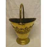 A good quality old brass oval coal bucket with raised scroll decoration and loop handle