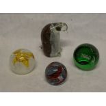Three various Caithness circular paperweights and a glass penquin paperweight (4)